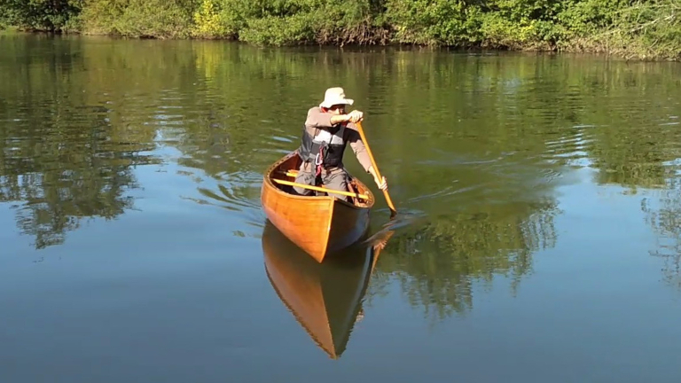 Image 1 - Solo canoe paddler in a wooden canoe on a river
