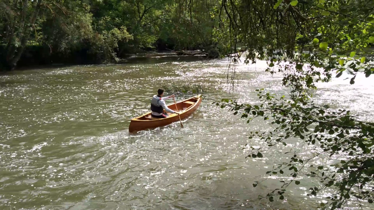 Image 3 - Solo canoe paddler on a river close to a waterfall in a gentle eddy